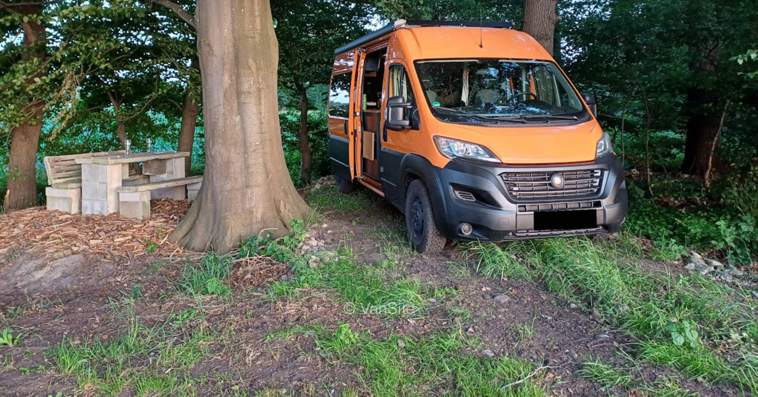 Flusslager unter Bäumen